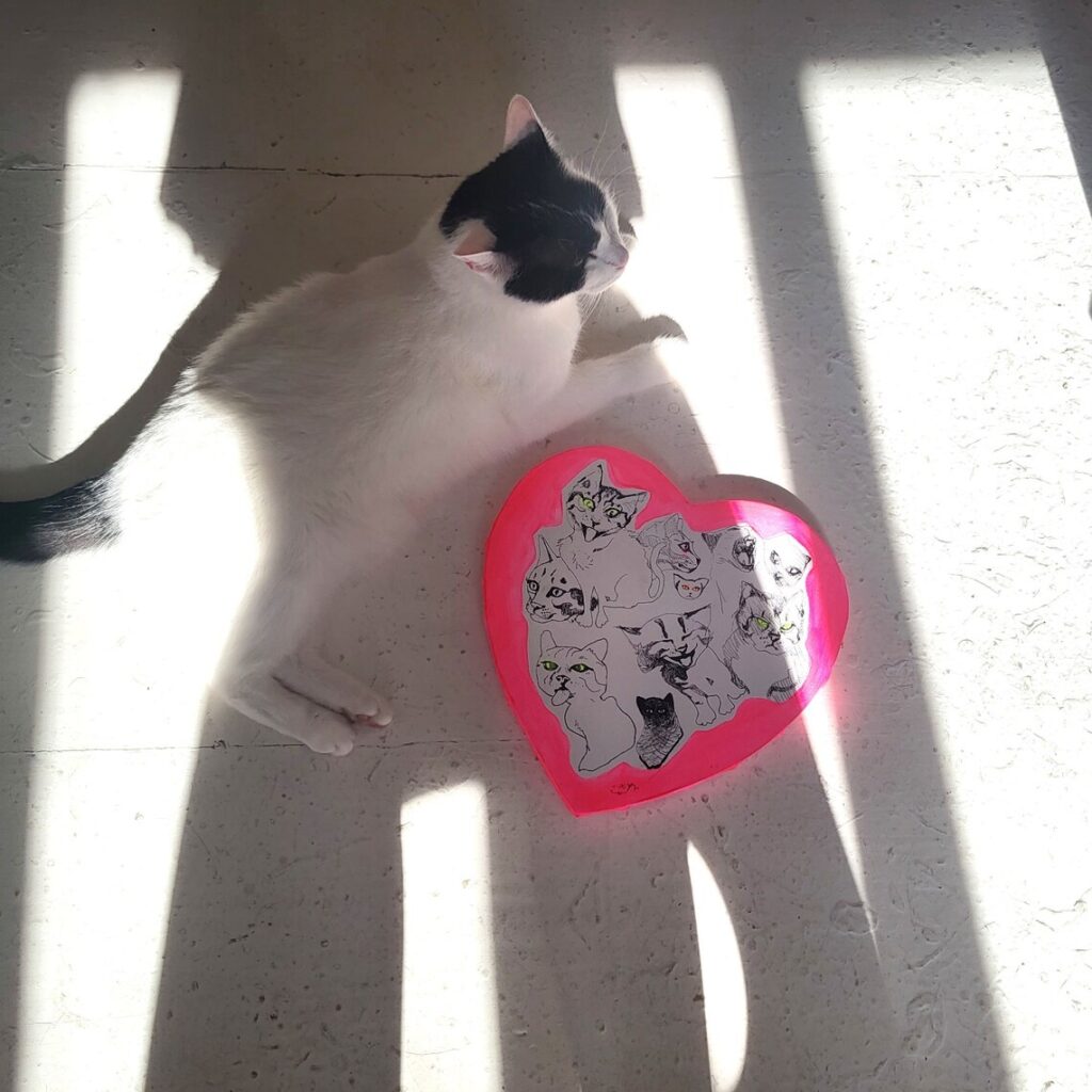 ハート型のアクリル原画 猫の絵画と本物の猫が写ったイメージ